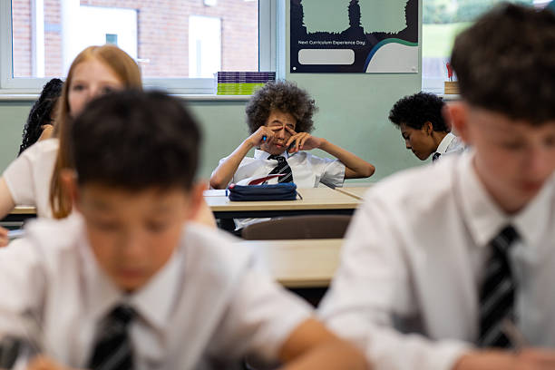 istock Tired Student Sitting at Desk During Classroom Lesson 2241138100