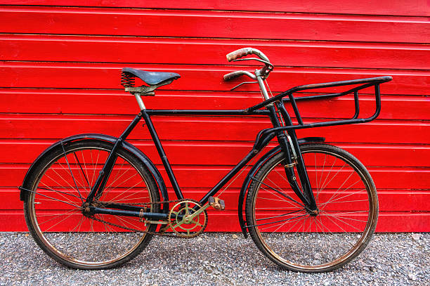 istock Black vintage bicycle on red wooden wall background. 2241142799