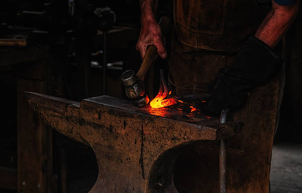 istock The blacksmith manually forging the molten metal on the anvil in smithy. 2241142842