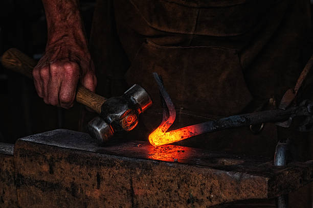 istock The blacksmith manually forging the molten metal on the anvil in smithy. 2241142854