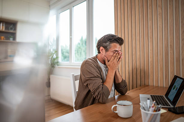 istock Stressed man rubbing eyes working from home 2241143713