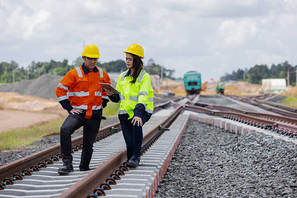 istock Two railway engineers wearing safety helmets and reflective jackets inspect concrete sleepers and rail alignment using a tablet. The image shows teamwork, precision, and infrastructure development. 2241144451