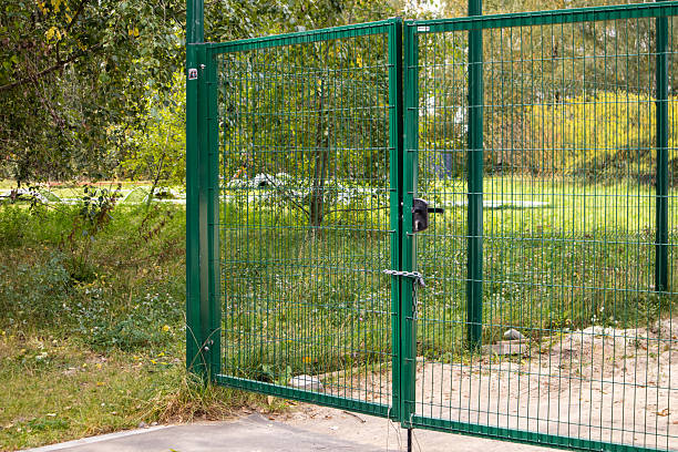 istock Metal mesh gate with lock and chain on green area horizontal photo 2241145620