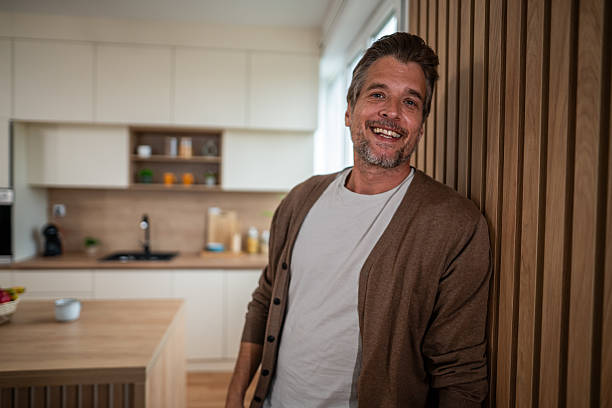 istock Happy mature man smiling in modern kitchen 2241146879