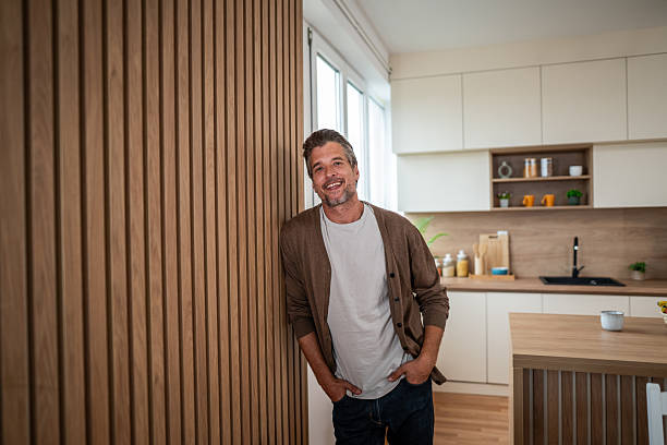 istock Smiling man standing in modern kitchen at home 2241146880