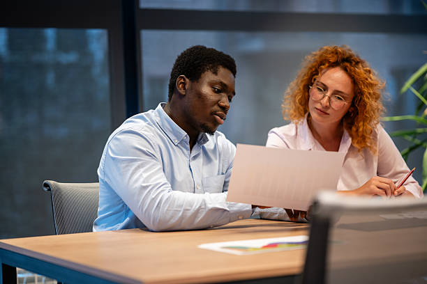 istock Business colleagues discussing financial report in modern office setting 2241147133