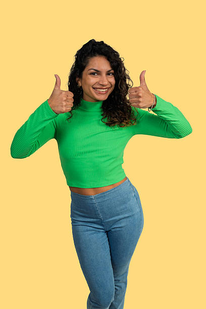 istock Young woman smiling, giving two thumbs up gesture 2241148202