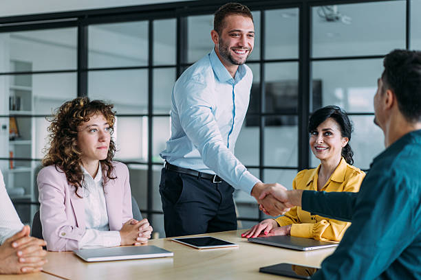 istock Businesspeople shaking hands across the table. 2241148529