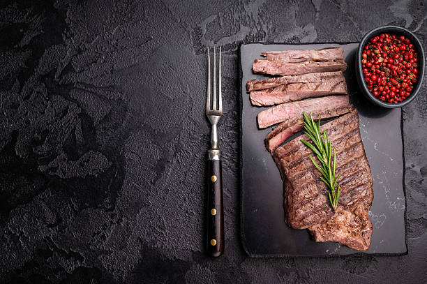 istock Grilled medium beef Rump steak on marble board. black background. top view 2241148617