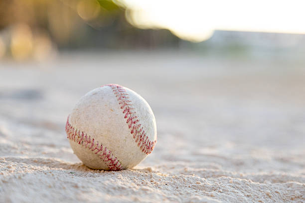 istock Baseball ball resting on sandy field at sunset 2241150150
