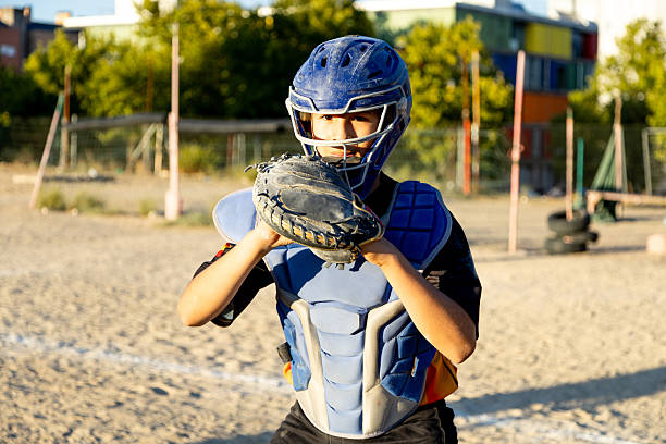 Portrait african american pitcher ready to make a catch with a mitt on a baseball field. Young sportsman in a helmet ready for the ball. Black man athlete playing a game or match on pitch outdoors
