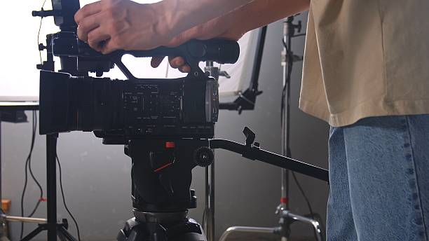 istock Cameraman Adjusting Professional Video Camera on Tripod 2241150400