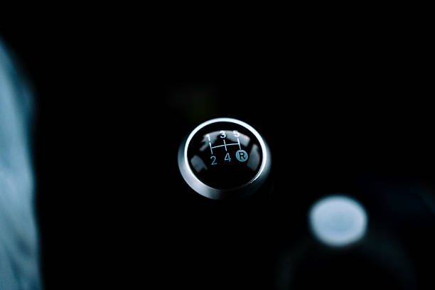 Close-up photo of a manual transmission gear shift lever inside a modern vehicle, showing gear positions from first to reverse.
