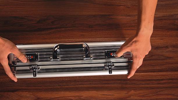 istock Hands Unlocking Metal Security Briefcase on Wooden Table 2241151006