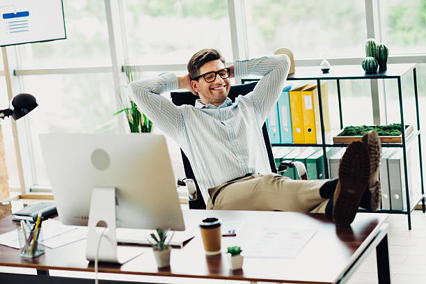 istock Businessman relaxing confidently in a modern office workspace surrounded by technology and stylish decor on a productive day 2241153747