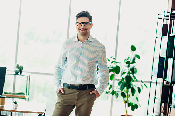 istock Confident young professional posing in modern office with elegant attire and a smile, representing success and style 2241153749