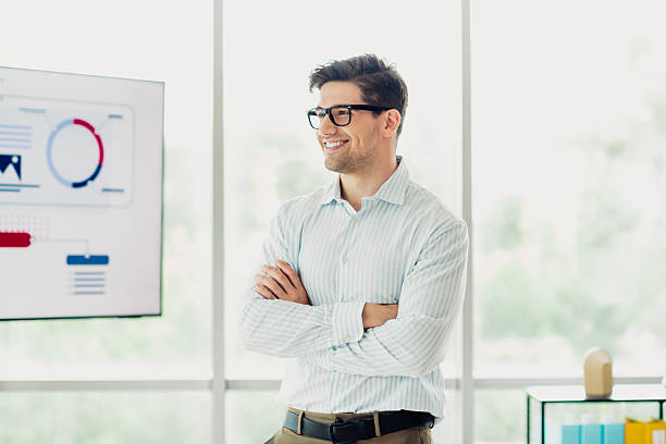 istock Confident young businessman in office setting presenting charts with a professional demeanor and trendy appearance 2241153930