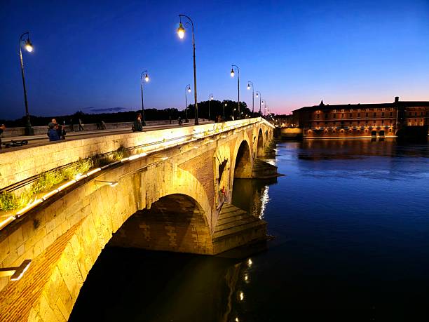 The Pont Neuf is a bridge from the 16th and 17th centuries in Toulouse, in the South of France. The image shows the bridge at dusk during spring season.