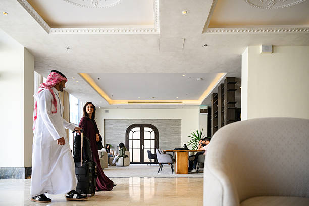 istock Side view of a Middle Eastern couple walking through a refined hotel lobby with modern ceiling details and bright natural light 2241156608