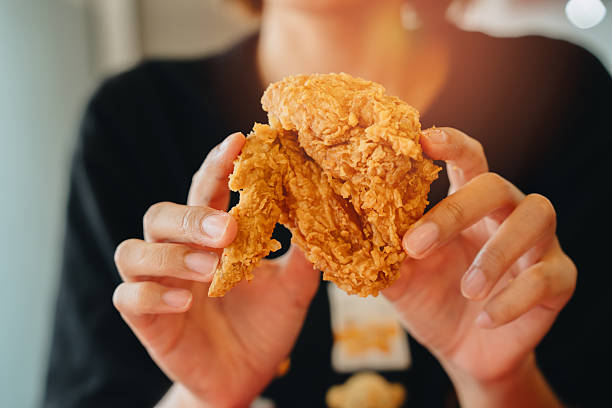 istock Fried chicken concept. Crispy Fried Chicken Piece Held by Hands with Golden Brown Crust in Bright Natural Light and Soft Focus Background 2241156881