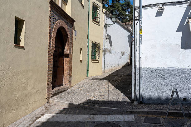 Tourists strolling in the Carrera del Darro, a narrow cobblestone street, one of the oldest and charming in the city, where, among the historic buildings, stands out the Convent of Dominican nuns dedicated to St. Catherine of Siena, founded in 1520.