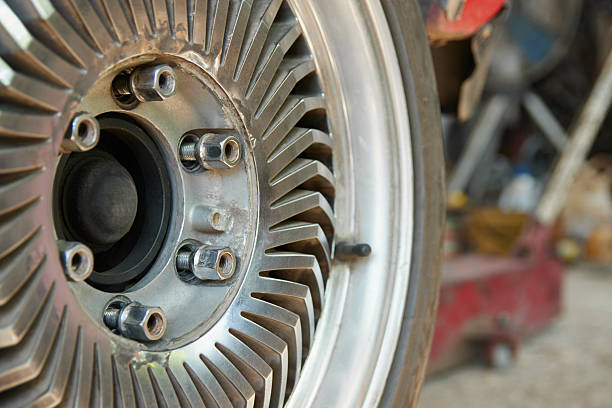 Mechanical Engineering or Industry Concept by Classic or Vintage Car Wheel or Hub and Wheel Nut in Auto Repair Shop