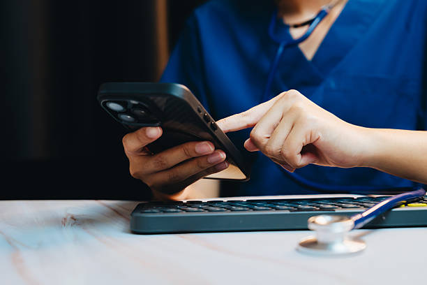istock Doctor Using Smartphone and Computer Keyboard for Patient Care in Modern Medical Environment 2241157646