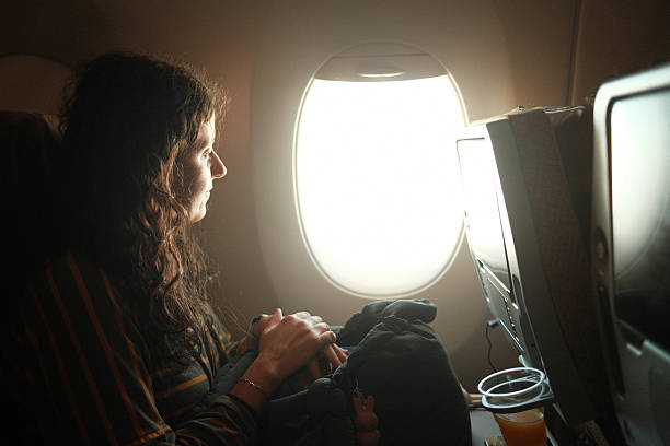 istock Woman looking out airplane window during flight journey 2241157924