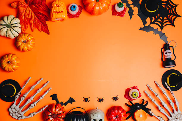 istock Halloween concept. Festive Halloween Decorations with Pumpkins, Candles, and Spooky Elements on an Orange Background for Holiday Celebrations 2241159038