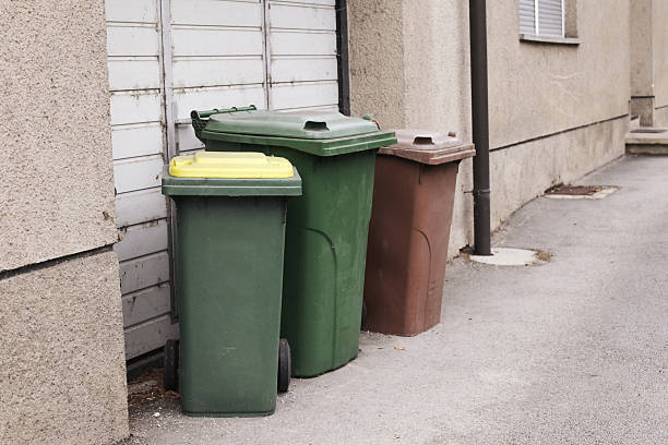 istock Colorful garbage bins for waste segregation standing near building wall. 2241159291
