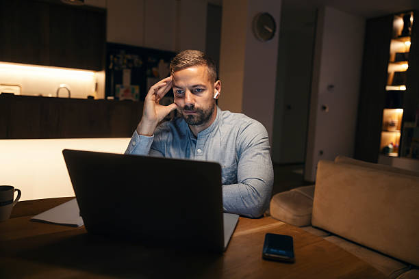 istock Man concentrating working late on laptop at night 2241161223