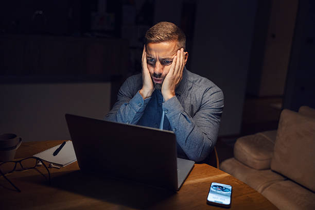 istock Stressed man working on laptop late at night 2241161254