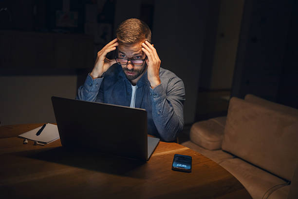 istock Man feeling pressure working late on laptop 2241161303