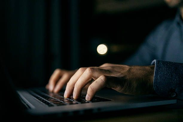 istock Person typing on laptop keyboard at night 2241161434