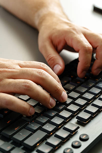 istock Hands typing on a dark keyboard in a modern workspace during the day 2241162052
