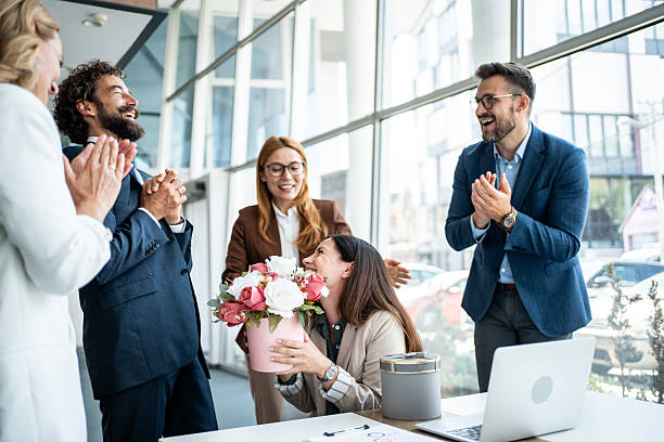 istock Office colleagues celebrating success, giving flowers as a gift 2241165468