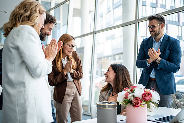 istock Office colleagues celebrating with surprise gift and applause 2241165584