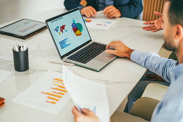 istock Business people sharing ideas inside company office - Multiracial colleagues discussing new financial project - Data analysis and corporate concept - Main focus on man right hand 2241168427