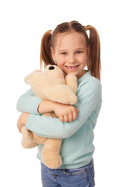 istock Smiling girl hugging teddy bear on white background 2241169941