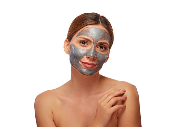 istock Woman applying a revitalizing silver clay mask to her face 2241170107