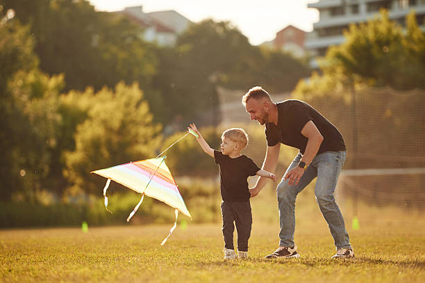 istock Active weekend, running with kite in hand. Happy father with son on the field 2241170738