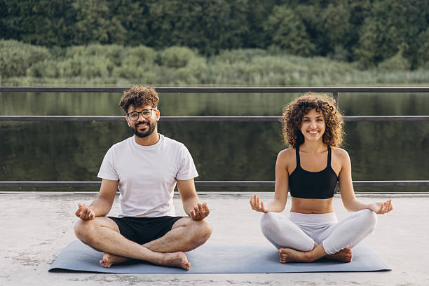istock Couple meditating outdoors by the lake enjoying nature 2241171987