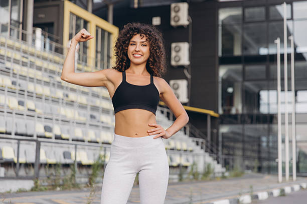 istock Young sportswoman showing her biceps at the stadium 2241175276