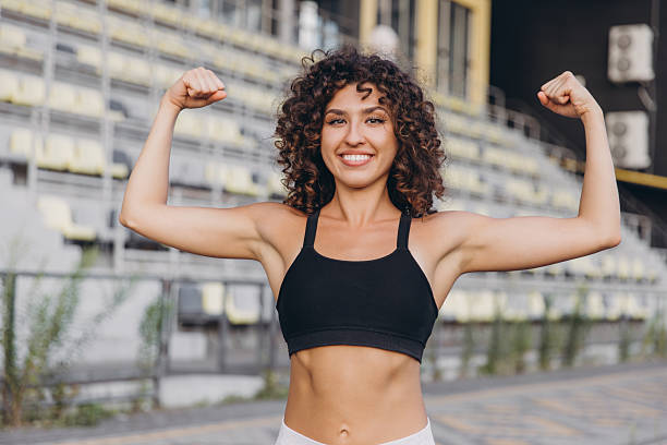 istock Young athlete showing her biceps at the stadium 2241175314