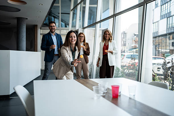 istock Colleagues playing beer pong in modern office during break 2241176865