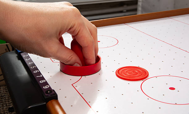 istock Hand ready to hit with paddle on puck. The portable table hockey includes plastic hockey paddles, a mini puck and score keepers. Hobby game background with copy space. High quality 2241180500