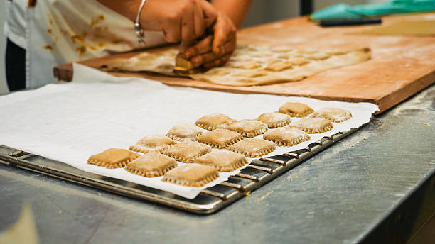 Skilled Chef Handcrafting Fresh Pasta Dough Squares for Culinary Delights in a Professional Kitchen Environment