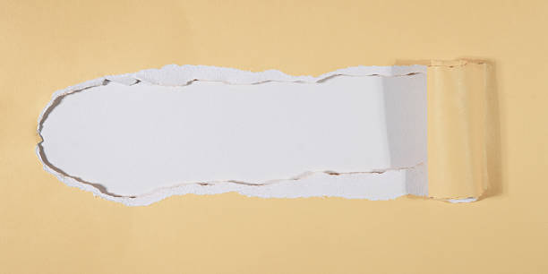 istock Greeting card, festive abstract texture postcard frame template - Torn paper hole in yellow paper with curled rolled edges, pastel beige empty background 2241188263