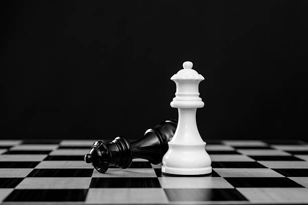 istock White queen standing and black queen falling 2241188648