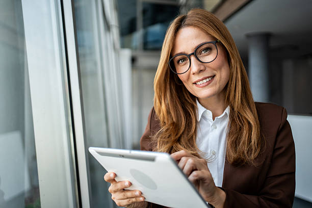 istock Businesswoman smiling and working on digital tablet 2241192939
